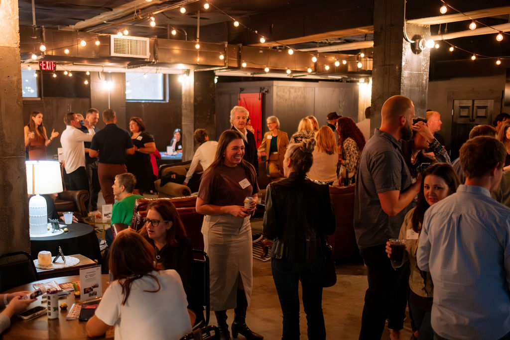 A full room of attendees networking at The Shop DSM